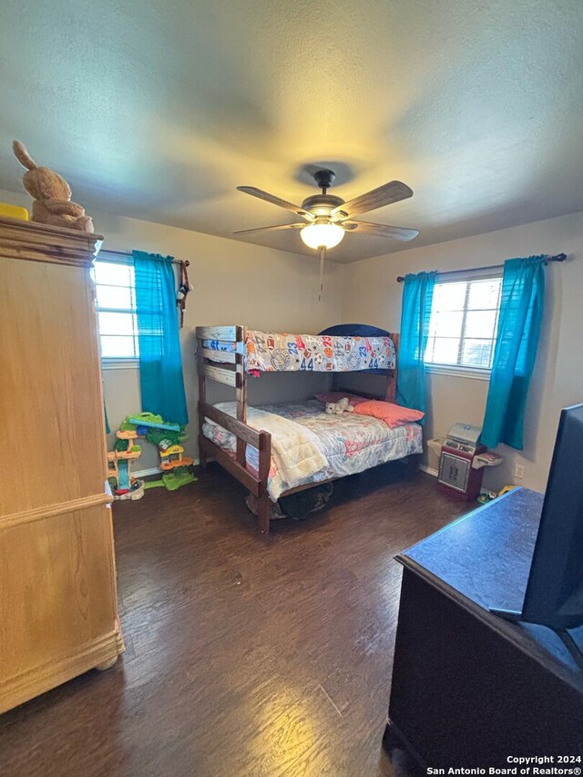 bedroom with a textured ceiling, ceiling fan, and hardwood / wood-style flooring