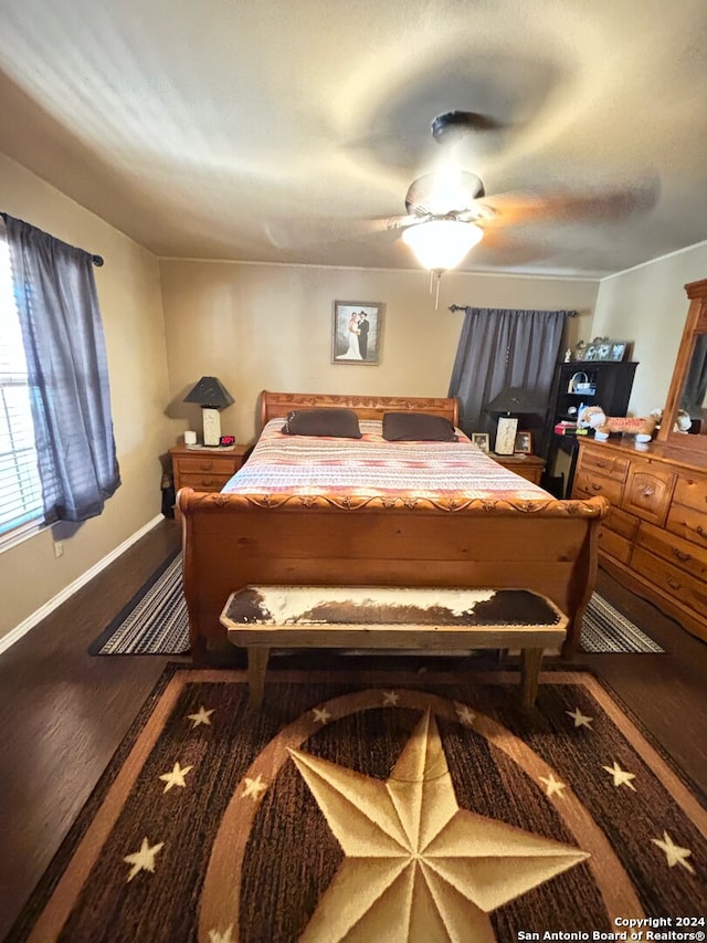 bedroom with ceiling fan, baseboards, and wood finished floors