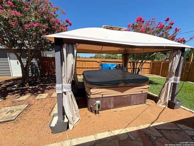 view of yard featuring central AC unit, a hot tub, and a gazebo