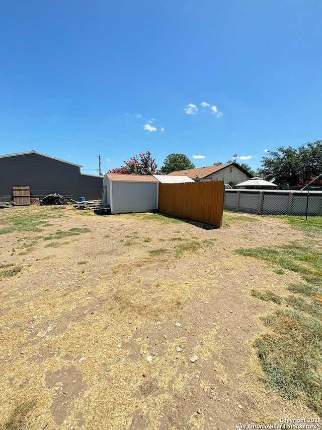 view of yard with an outbuilding, an outdoor structure, and fence