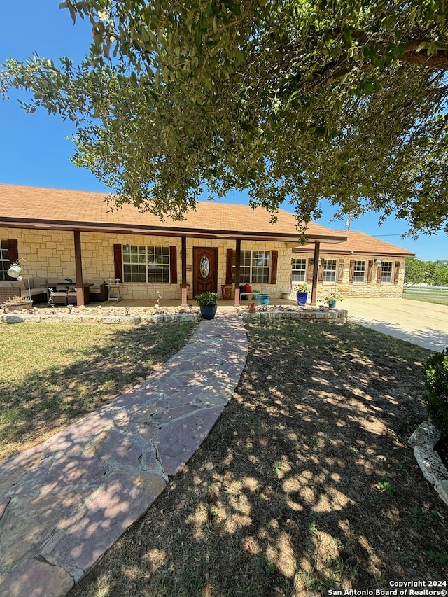 ranch-style house with stone siding and a porch