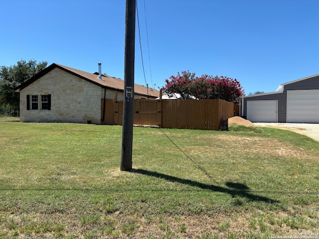 view of yard with a garage and an outbuilding