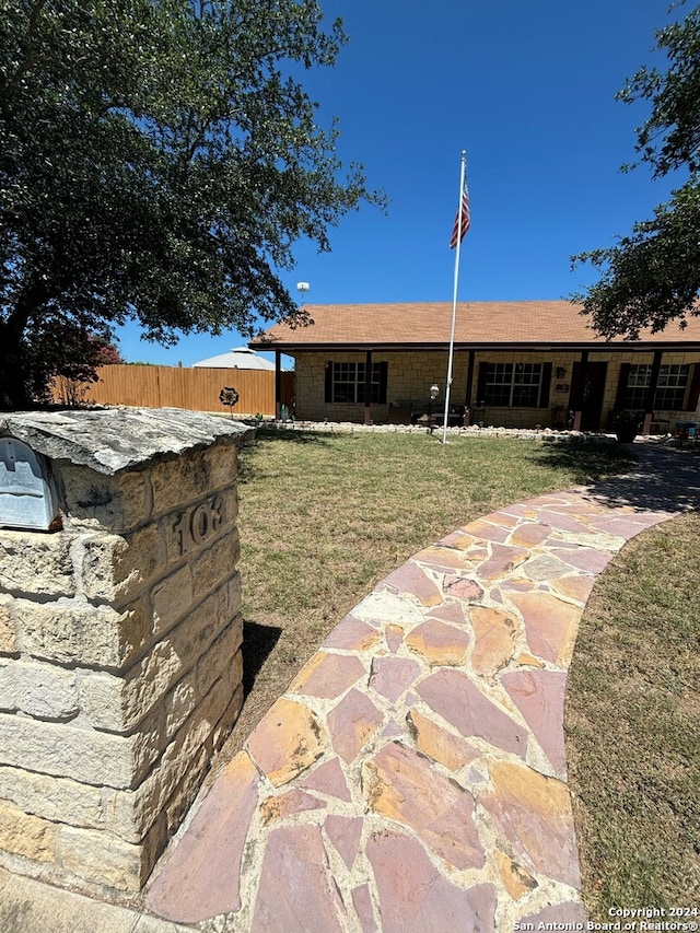 exterior space featuring a front lawn and fence