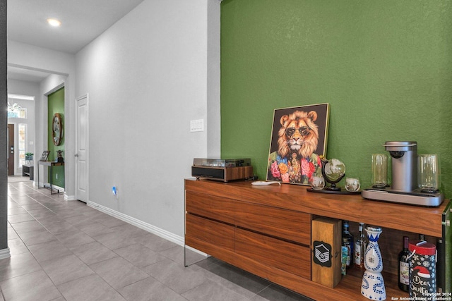 hallway featuring baseboards and light tile patterned floors