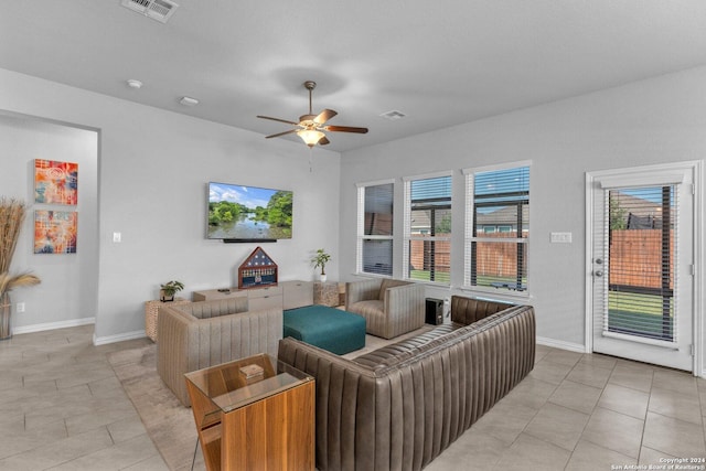 living room with light tile patterned floors, baseboards, visible vents, and a ceiling fan