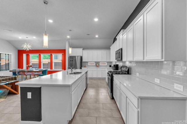 kitchen with an island with sink, stainless steel appliances, white cabinetry, pendant lighting, and a sink