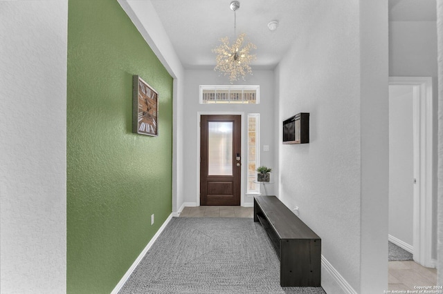 foyer featuring visible vents, a textured wall, baseboards, and light tile patterned floors