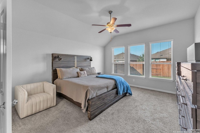 bedroom with light colored carpet, vaulted ceiling, baseboards, and ceiling fan