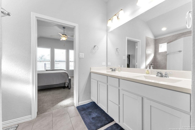 full bath featuring connected bathroom, tile patterned flooring, a sink, and lofted ceiling