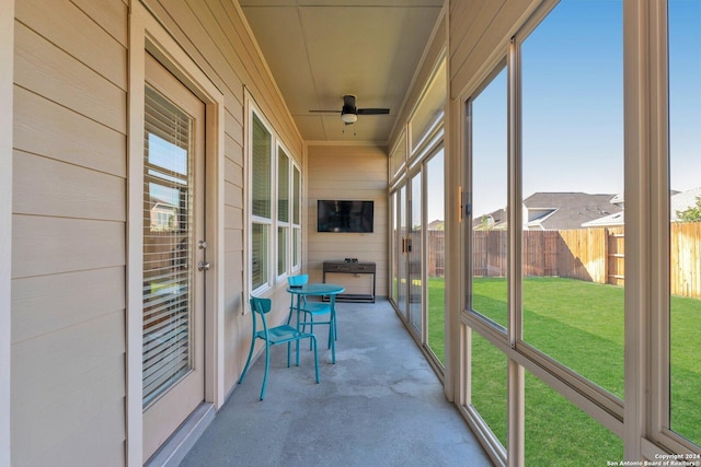 unfurnished sunroom with a ceiling fan