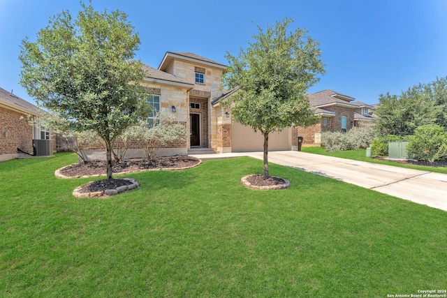 view of front of home featuring an attached garage, central AC, stone siding, driveway, and a front lawn