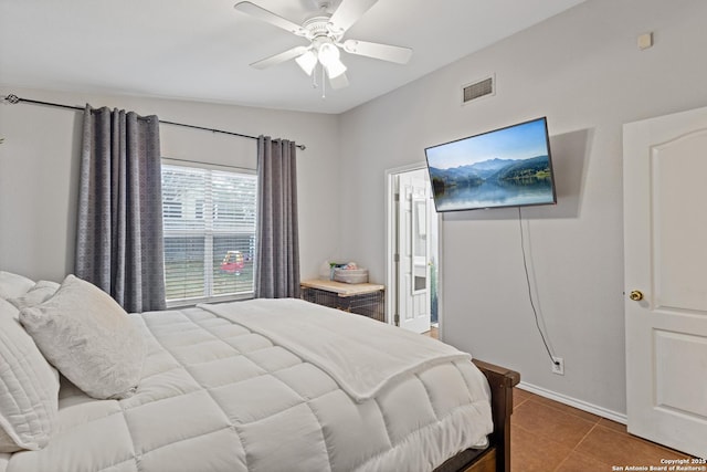 tiled bedroom featuring ceiling fan