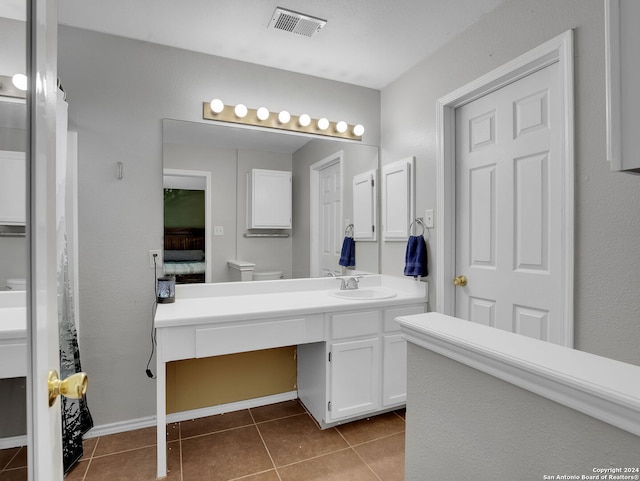 bathroom with vanity, tile patterned floors, and toilet