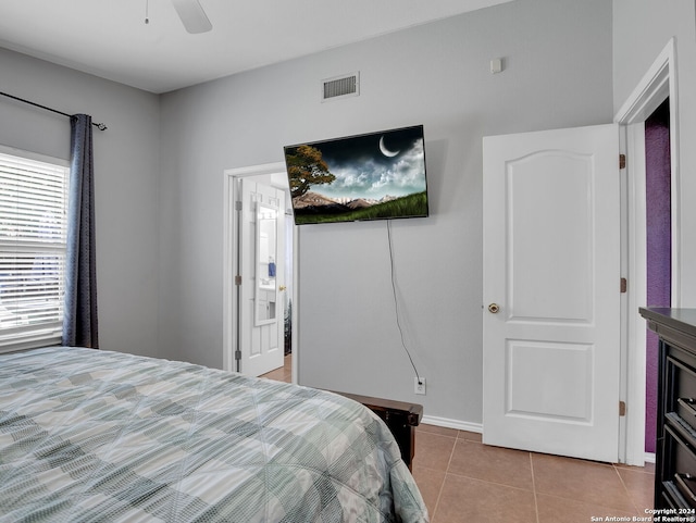 tiled bedroom with ceiling fan and connected bathroom