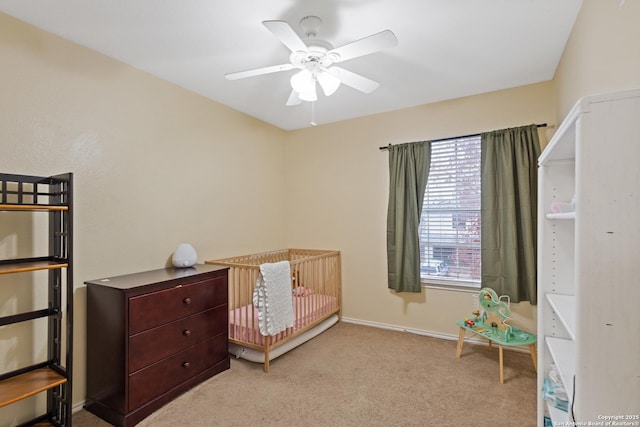 carpeted bedroom with a nursery area and ceiling fan