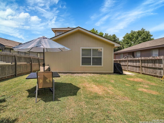 rear view of house featuring a yard