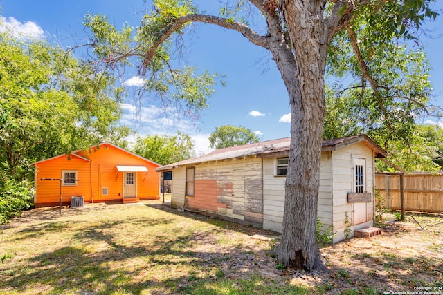 back of property featuring cooling unit and a yard