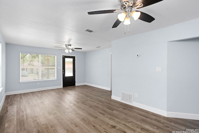 spare room with ceiling fan, a textured ceiling, and hardwood / wood-style flooring