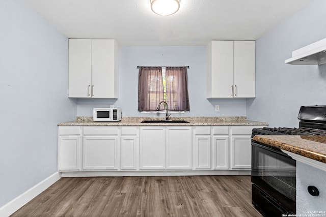 kitchen with light hardwood / wood-style flooring, sink, white cabinets, and light stone countertops