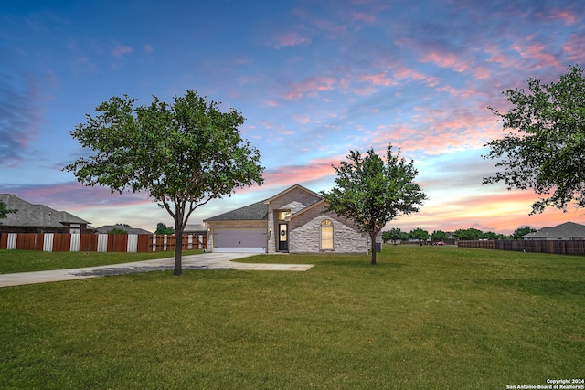 view of front of home with a garage and a yard