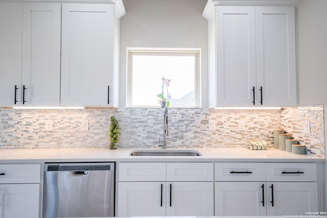 kitchen with decorative backsplash, sink, dishwasher, and white cabinetry