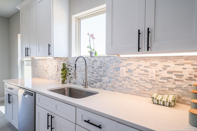 kitchen featuring white cabinets, sink, tasteful backsplash, and stainless steel dishwasher