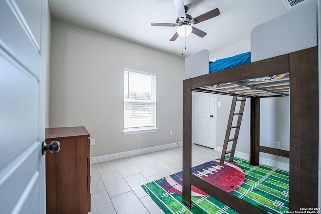 tiled bedroom featuring ceiling fan and a closet