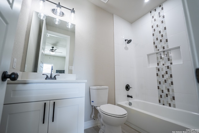 full bathroom featuring toilet, wood-type flooring, tiled shower / bath, ceiling fan, and vanity