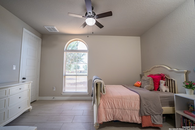 bedroom featuring ceiling fan and a textured ceiling