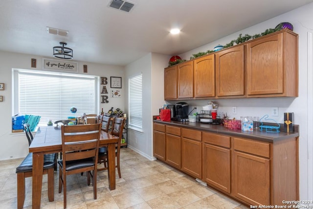 3802 Blue Oak Pass, San Antonio, TX 78223 - kitchen with dark countertops, plenty of natural light, brown cabinets, and visible vents