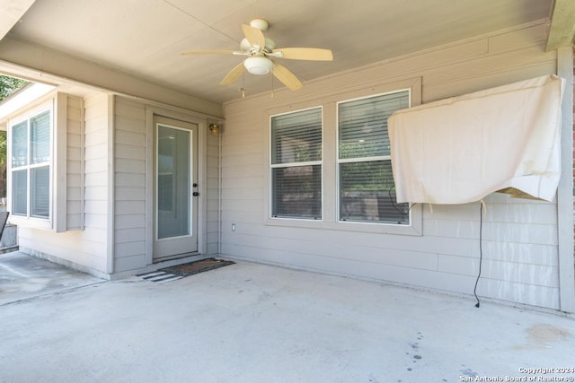 entrance to property featuring ceiling fan and a patio area