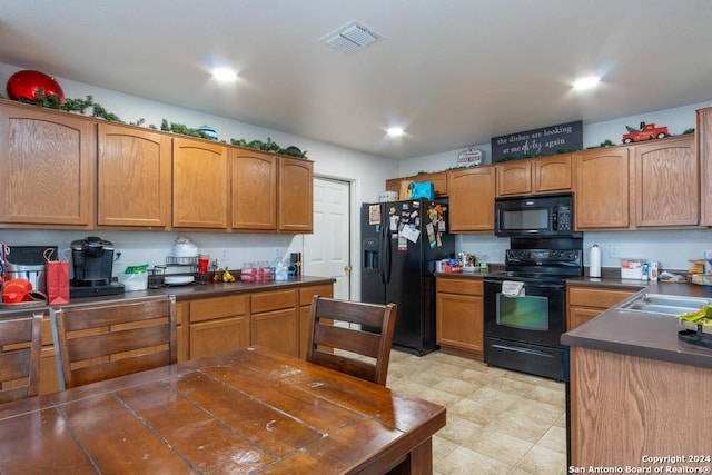 kitchen with light tile patterned flooring, sink, and black appliances