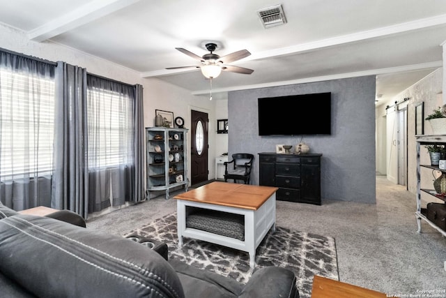 carpeted living area featuring a barn door, visible vents, and a ceiling fan