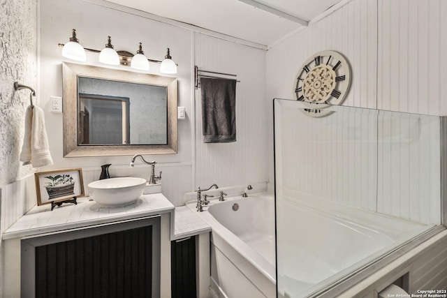 full bathroom with a decorative wall, vanity, and a garden tub
