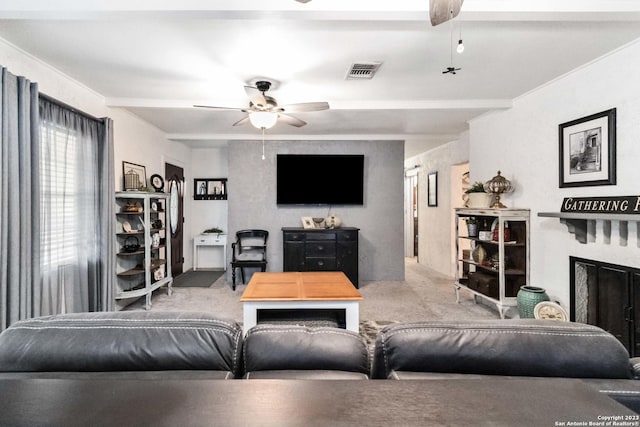 carpeted living room with ornamental molding, visible vents, ceiling fan, and a fireplace
