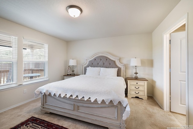 bedroom with light carpet and baseboards