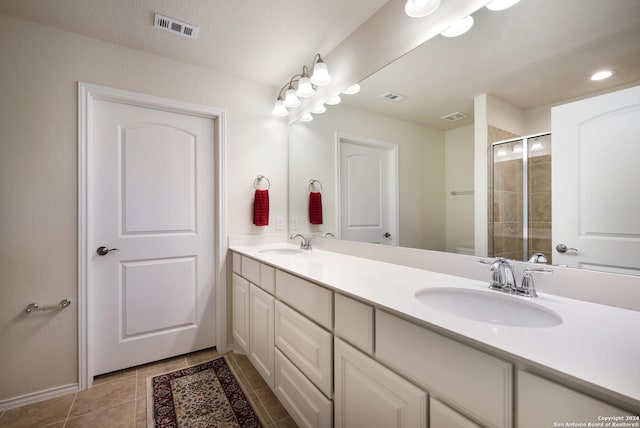 bathroom featuring a stall shower, a sink, and visible vents