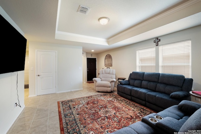 living area featuring a tray ceiling, visible vents, ornamental molding, light tile patterned flooring, and baseboards