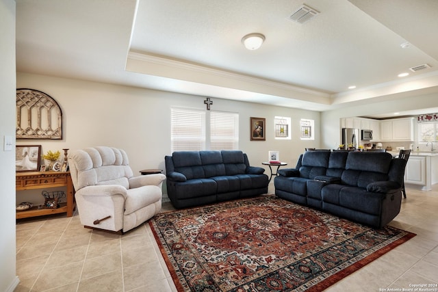 living area with ornamental molding, a raised ceiling, visible vents, and light tile patterned floors