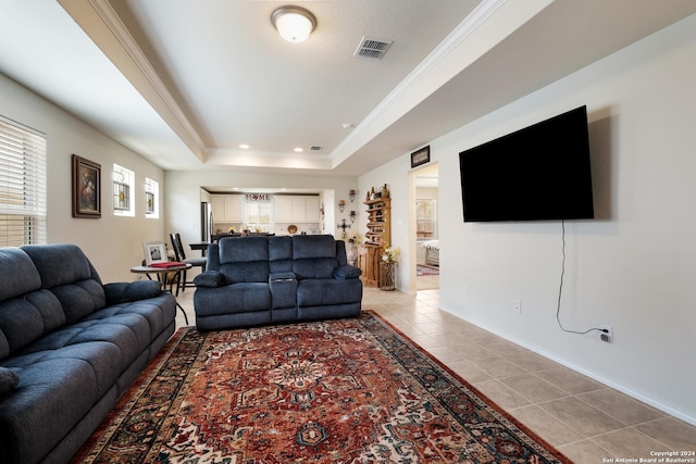 living area with light tile patterned floors, ornamental molding, a raised ceiling, and visible vents