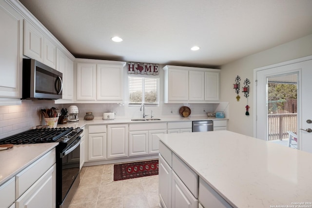 kitchen featuring white cabinets, appliances with stainless steel finishes, light countertops, and a sink