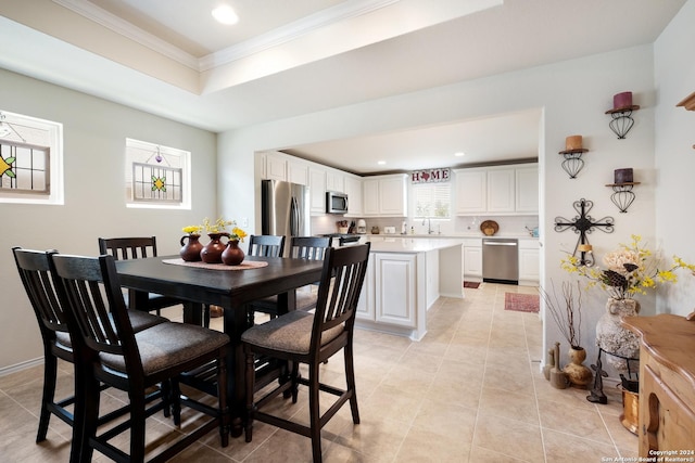 dining room featuring light tile patterned flooring, recessed lighting, baseboards, ornamental molding, and a raised ceiling