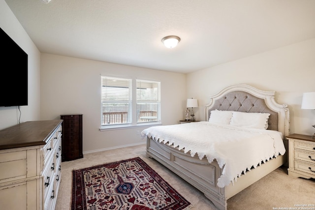 bedroom with baseboards and light colored carpet