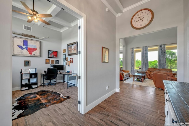 interior space with beam ceiling, ornamental molding, and wood-type flooring