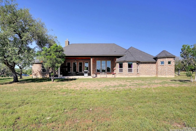 rear view of property with a patio and a yard