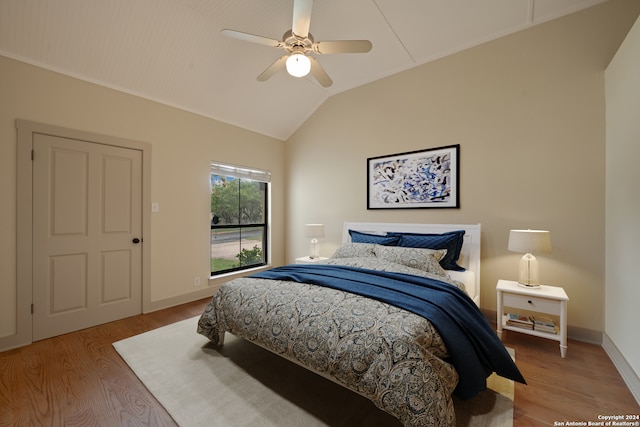 bedroom featuring light hardwood / wood-style floors, vaulted ceiling, and ceiling fan