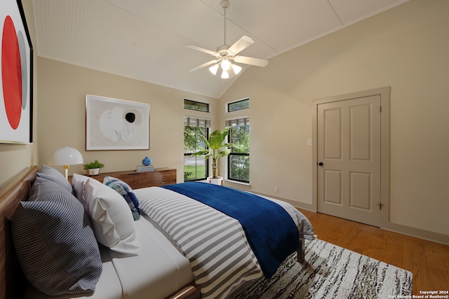 bedroom with ceiling fan, vaulted ceiling, and wood-type flooring