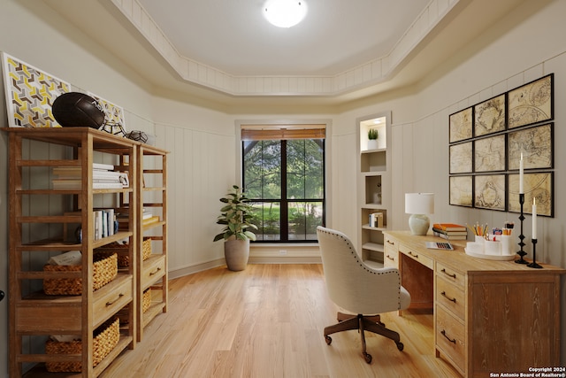 office space featuring light hardwood / wood-style floors and a raised ceiling