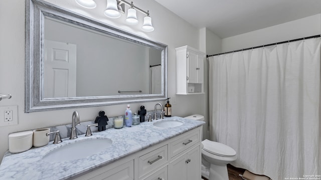 bathroom with double vanity and toilet