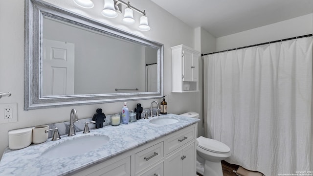 full bath featuring a sink, toilet, and double vanity